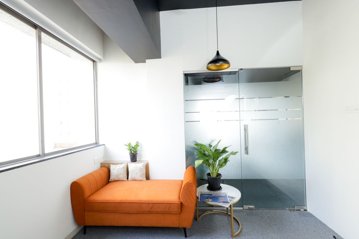 Lounge corner with sofa beside glass cabins, managed office built by Workin Space