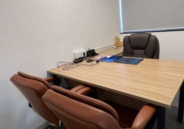 A professional meeting room featuring a long table and an LED screen - WorkinSpace.